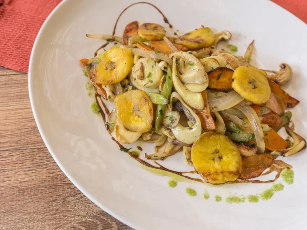 White plate with sauteed vegetables on wooden background