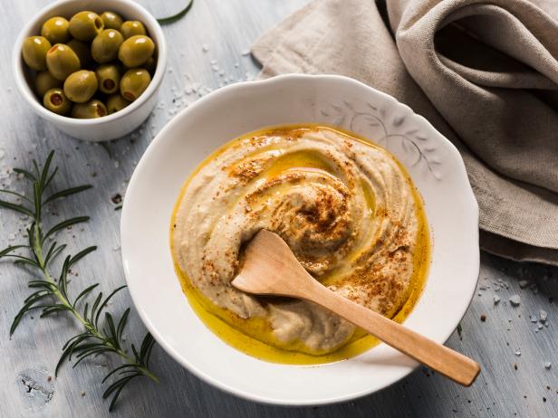 Home made humus bowl, decorated with olive oil over a rustic wooden clear background. Top View