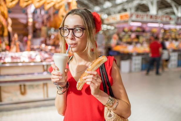 Woman portrait with Horchata, traditional spanish drink made from almonds, standing in the Central foodmarket of Valencia city