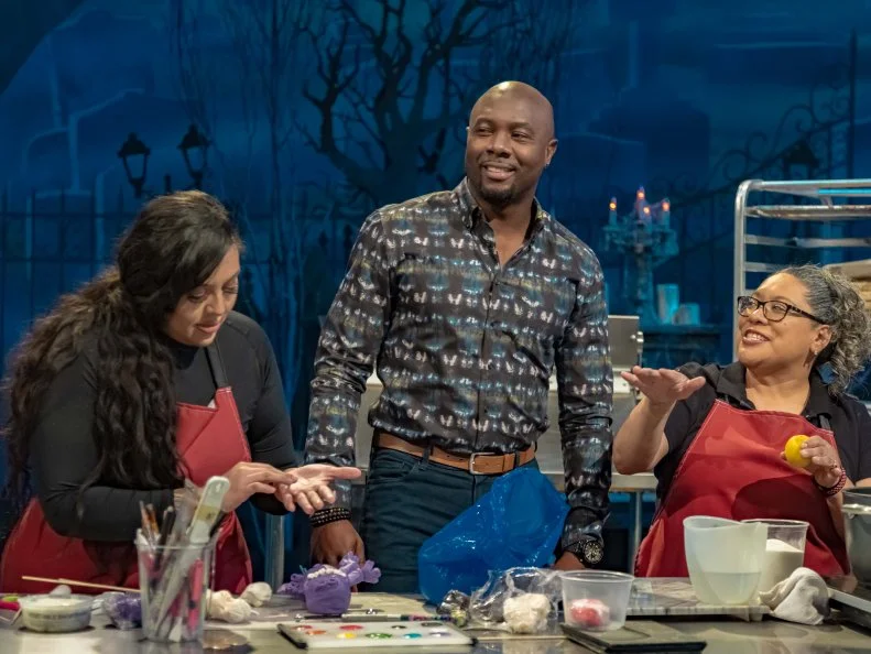 Host Eddie Jackson speaks with Lizzeth Rascon and Yliana Cadena, as seen on Halloween Wars, Season 11.