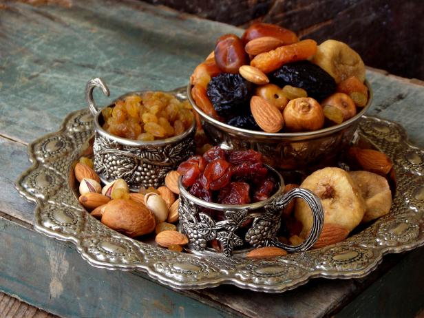 A composition from different varieties of dried fruits on a wooden background - dates, figs, apricots, prunes, raisins, cranberries. Healty food
