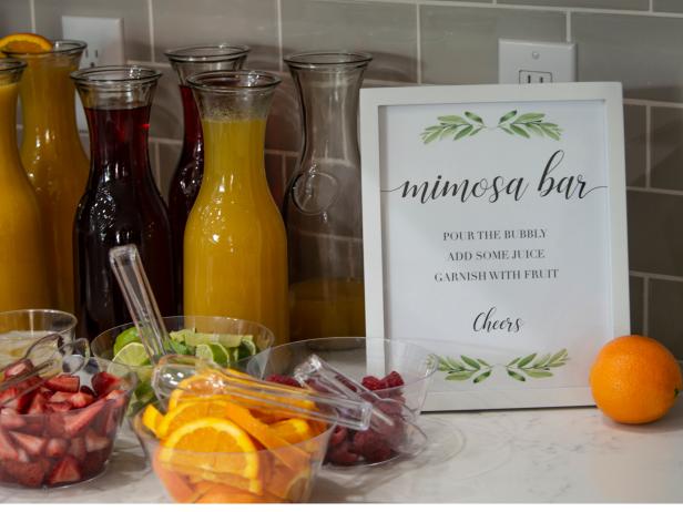 A mimosa bar complete with freshly sliced oranges, strawberries, limes, and raspberries.
