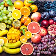 A colourful spectrum of fruit: oranges, lemons, limes, mandarins, grapes, plums, grapefruit, pomegranate, persimmons, bananas, cherries, apples, mangoes, blackberries and blueberries.