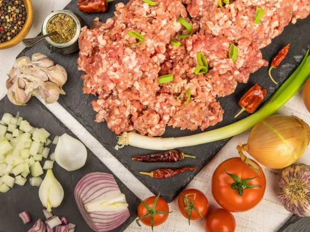 Freshly prepared meatloaf ready for the oven with ingredients. Minced meat with chili spices and sausage. Making classic meatloaf with ground beef.
