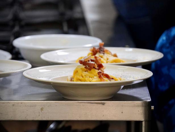 A traditional carbonara spaghettini made by chef Sarah Cicolini, Giada De Laurentiis, and Bobby Flay at Santo Palato, as seen on Bobby & Giada In Italy, Season 1.