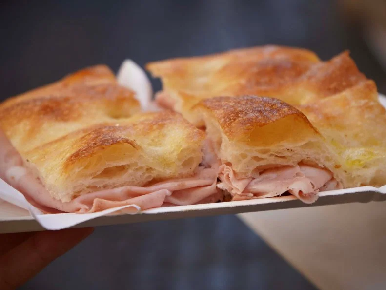 A close up of one of the items from Roscioli il Forno, a mortadella sandwich, as seen on Bobby & Giada In Italy, Season 1.