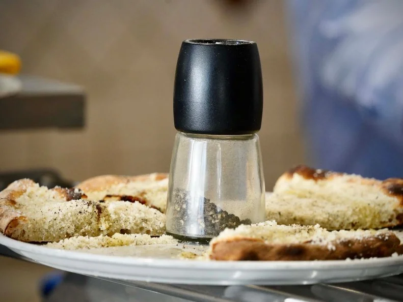 The final cacio e pepe pizza made by chef Stefano Callegari of Sforno for Bobby Flay and Giada De Laurentiis, as seen on Bobby & Giada in Italy, Season 1.