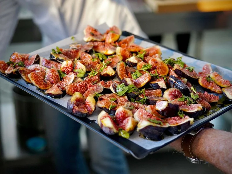 Bobby Flay holds up a tray of figs prepared to be made into gelato at Fatamorgana, as seen on Bobby & Giada in Italy, Season 1.