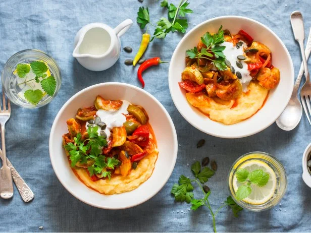 Mexican style spicy ratatouille with polenta on a blue background, top view. Flat lay