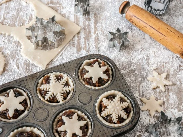 Making Christmas mince pies, with cut out pastry for tops and a rolling pin on a floury surface, part of a series.