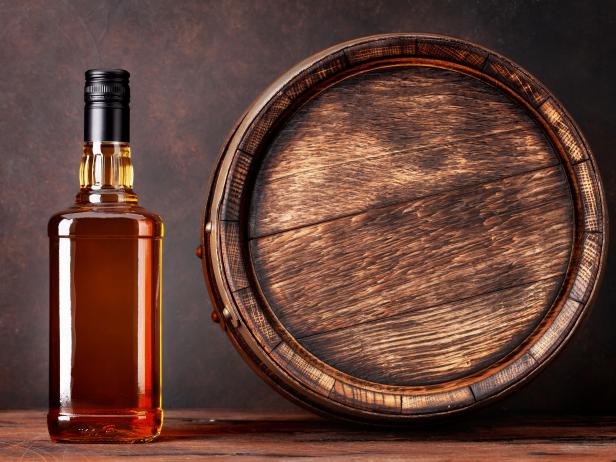 Scotch whiskey bottle and old wooden barrel. With copy space