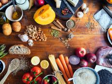 Colourful and healthy table composed with fruits and vegetables of many different types, meat, cheese, eggs, fish, spices and grains on wooden rustic table, view from above