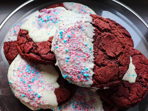 red velvet cookies dipped in white chocolate and decorated with colourful sprinkles