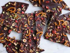 Roughly bashed salted pretzels and toasted hazelnuts are stirred into melted chocolate, then decorated with crushed freeze-dried red strawberries and green pistachios for extra color and flavor to complete this delicious, sweet treat.