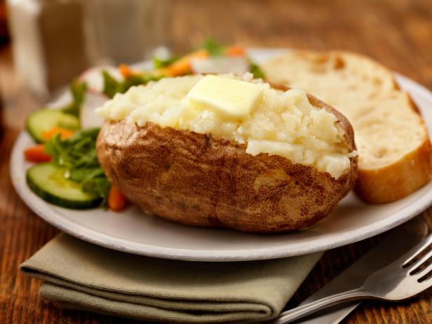 https://food.fnr.sndimg.com/content/dam/images/food/fullset/2021/11/09/baked-potato-butter-vegies-bread-fork-plate-linen-wood-surface.jpg.rend.hgtvcom.616.462.suffix/1636435993089.jpeg