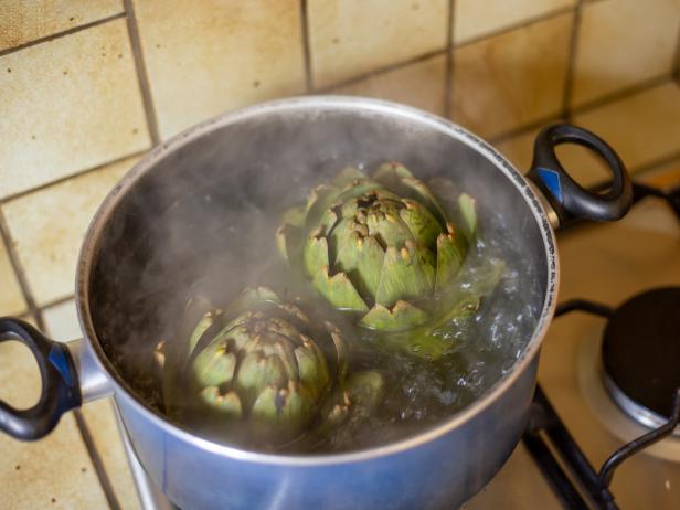artichokes are boiled in a saucepan. blurry artichoke, steamed artichokes