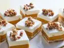 Description: Food Network Kitchen's Carrot Cake Cheesecake Bars. Keywords: Cinnamon, Eggs, Carrot Juice, Milk, Walnuts, Light Brown Sugar, Rolled Oats, Heavy Cream, Cream Cheese, Lemon Juice, Sour Cream, Vanilla Extract.