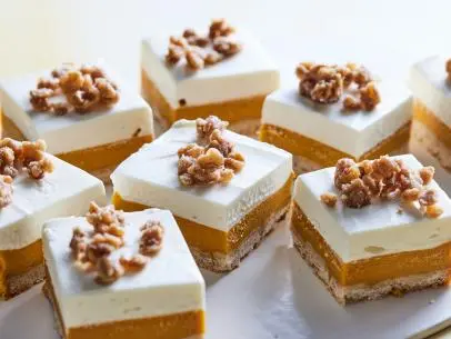 Description: Food Network Kitchen's Carrot Cake Cheesecake Bars. Keywords: Cinnamon, Eggs, Carrot Juice, Milk, Walnuts, Light Brown Sugar, Rolled Oats, Heavy Cream, Cream Cheese, Lemon Juice, Sour Cream, Vanilla Extract.