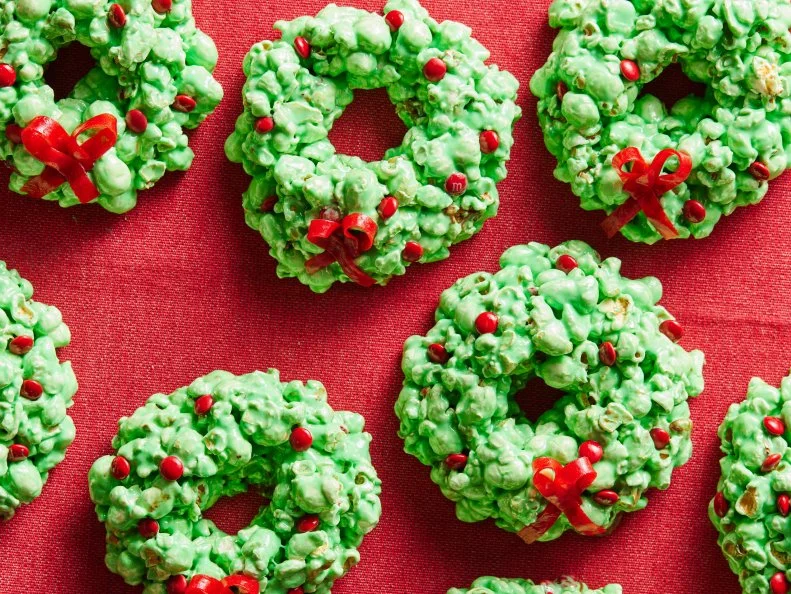 Description: Food Network Kitchen's Popcorn Ball Wreaths. Keywords: Popcorn, Marshmallows, Vanilla Extract, Green Food Coloring, M&Ms, Joray Candy.