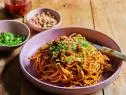 Description: Food Network Kitchen's Spicy Peanut Noodles. Keywords: Ramen Noodles, Peanut Butter, Chili Crisp, Toasted Sesame Oil, Soy Sauce, Rice Vinegar, Sugar, Ginger, Scallions, Honey-Roasted Peanuts.