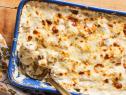 Description: Ree Drummond's Cheesy Au Gratin Potatoes. Keywords: Russet Potatoes, Heavy Cream, Milk, Fontina Cheese, Queso Blanco, White Cheddar, Chives.