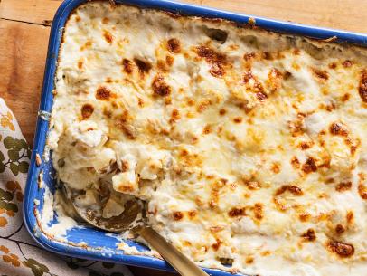 Description: Ree Drummond's Cheesy Au Gratin Potatoes. Keywords: Russet Potatoes, Heavy Cream, Milk, Fontina Cheese, Queso Blanco, White Cheddar, Chives.