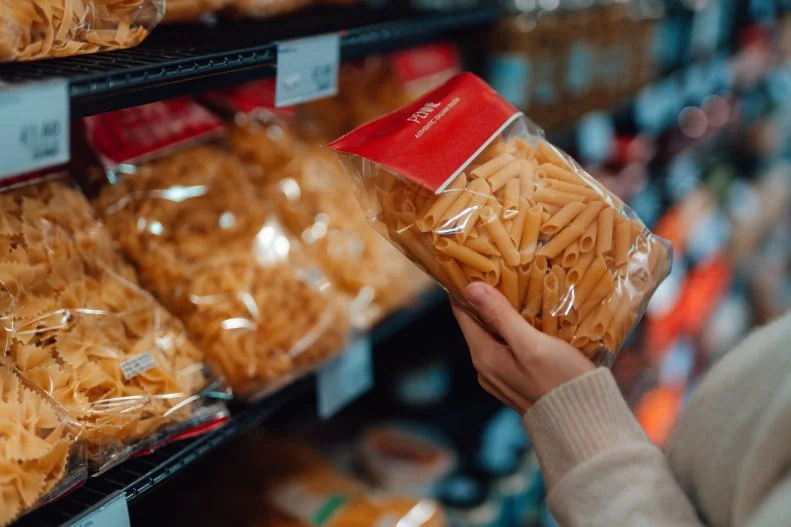 Close up shot of woman holding a bag of organic Italian pasta - Pennie. Healthy eating lifestyle. Home cooking theme.