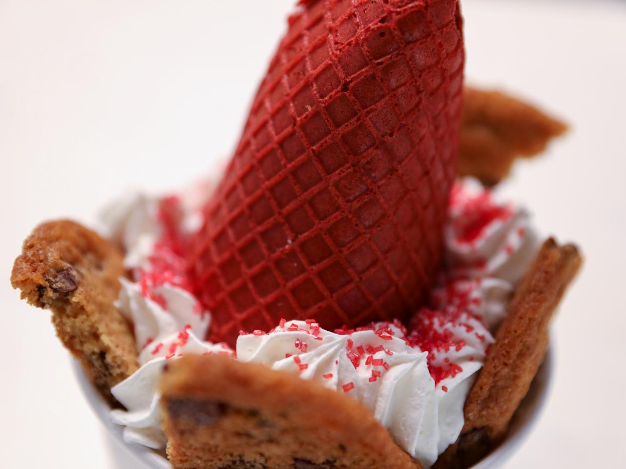 Waffle cone with heart-shaped marshmallows, close-up on a blue