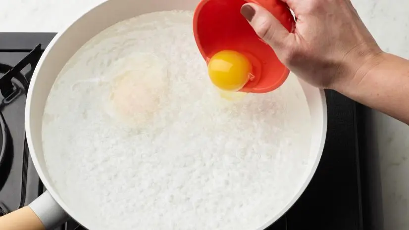 Food Network Kitchen's How to Poach An Egg Slip the Eggs Into the Water, as seen on Food Network.