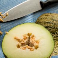 Piel de sapo melon cut in half showing the seeds.