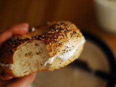 Bagel filled with cream cheese and milk for breakfast.