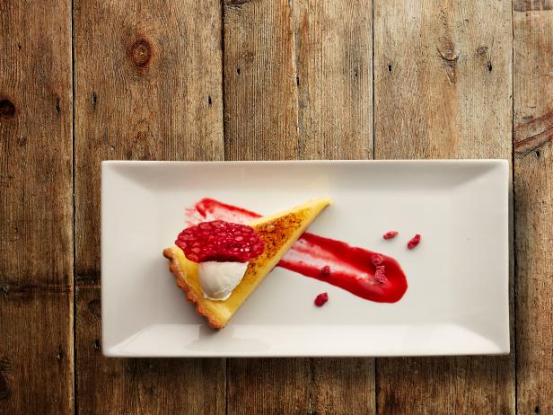 Directly above photograph of a stylish lemon tart with raspberry coulis