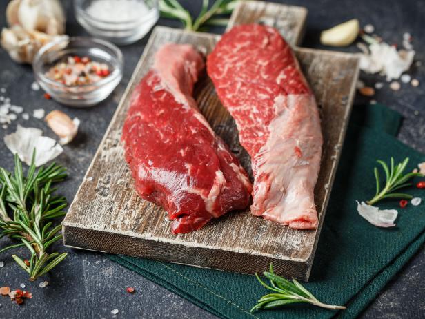 Raw Fresh Steak Sirloin Flap Served with Rosemary, garlic and spices on Wooden cutting Board. Black Angus Beef Meat. Close up.