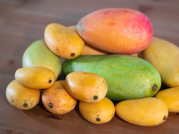 Stack of several varieties of Mangoes of different size and colors