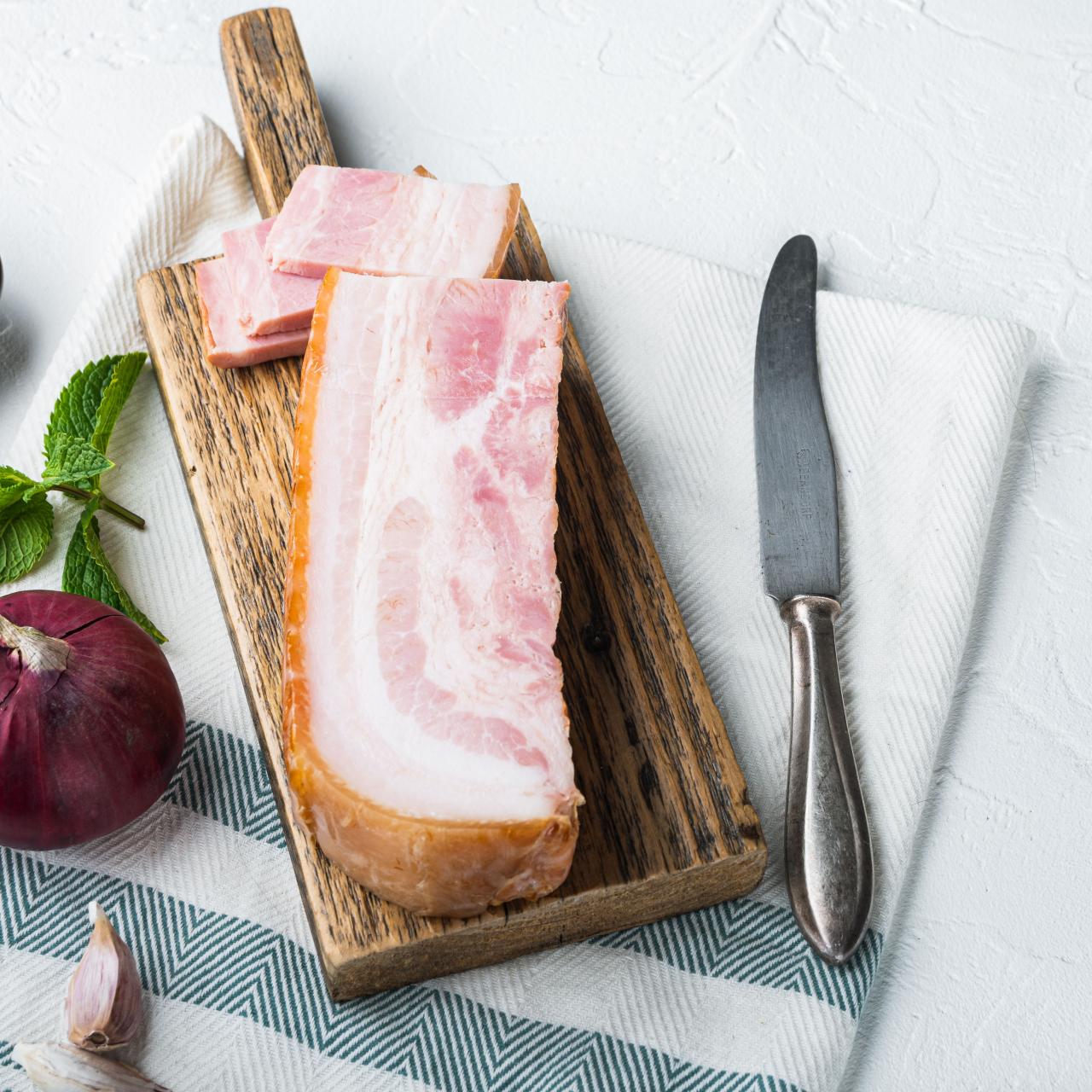 https://food.fnr.sndimg.com/content/dam/images/food/fullset/2022/01/07/pancetta-cutting-board-red-onion-mint-garlic-linen-knife.jpg.rend.hgtvcom.1280.1280.suffix/1641541198990.jpeg