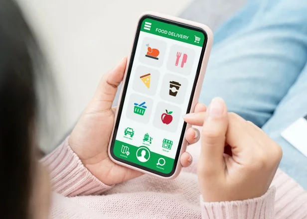 Back rear view of young asian teenage girl in concept next normal life from coronavirus impact using smart phone on hand and pay by credit card at home. Food delivery or grocery order service at home. (Back rear view of young asian teenage girl in con