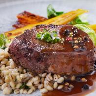 Seared Bison Fillet Steak with Creamy Mushroom Herb Barley, Roasted Carrots, Brussels Sprouts, Beet Puree and a Brandy Peppercorn Sauce