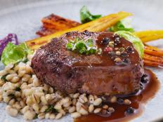 Seared Bison Fillet Steak with Creamy Mushroom Herb Barley, Roasted Carrots, Brussels Sprouts, Beet Puree and a Brandy Peppercorn Sauce
