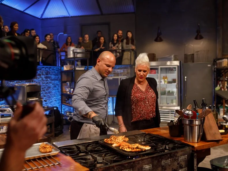 Co-host Anne Burrell checks in with contender Jonathan Dearden during Round 2, as seen on Beat Bobby Flay, Season 26.