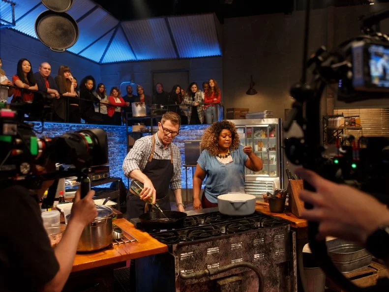 Behind the scenes of co-host Sunny Anderson taking a taste of chef Bobby Flay's rice, as seen on Beat Bobby Flay, Season 24.