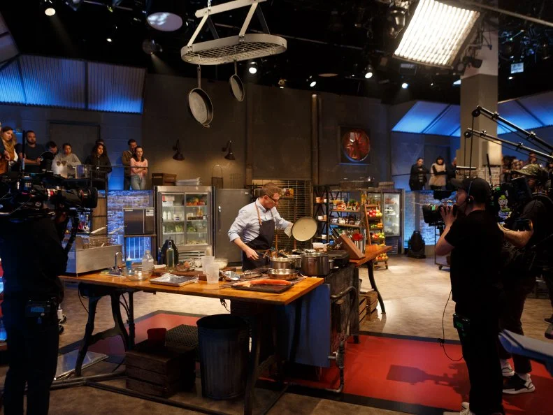 Bobby Flay cooking on set, as seen on Beat Bobby Flay, Season 22.