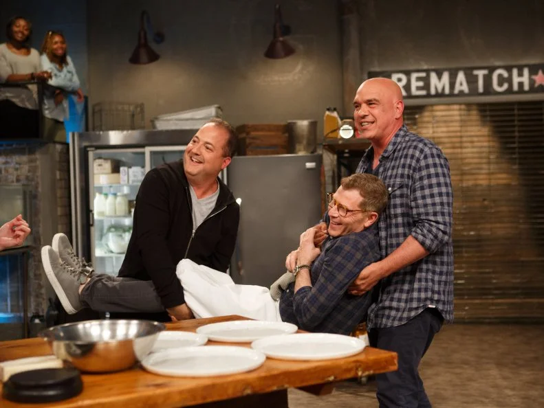 Co-Hosts Michael Simon and Josh Capon distract chef Bobby Flay, as seen on Beat Bobby Flay, Season 18.