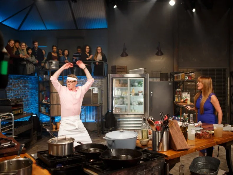 Co-Host Jane Seymour tests chef Bobby Flay with a set of jumping jacks, as seen on Beat Bobby Flay, Season 17.
