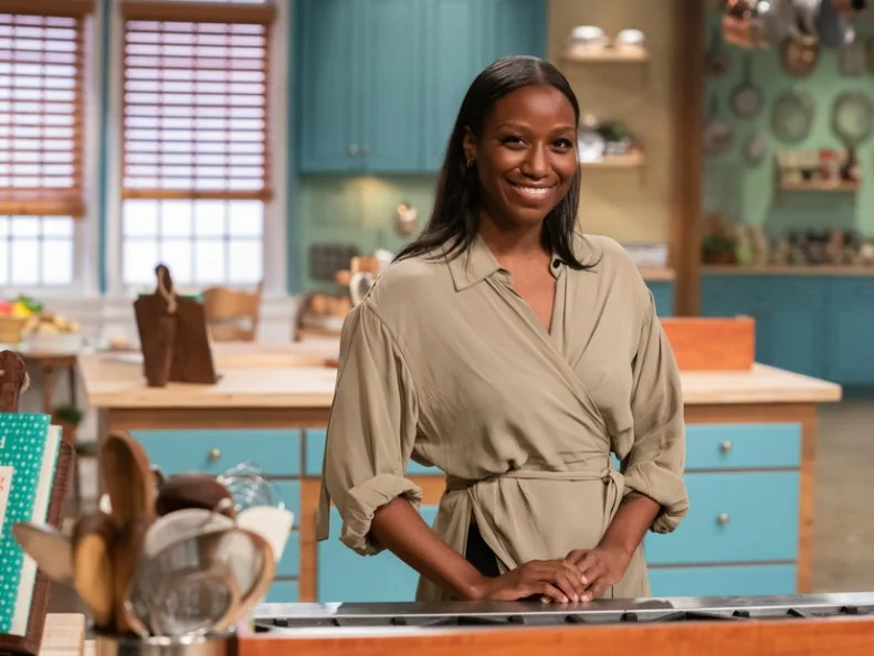 Contestant Britt Moore poses behind her station, as seen on Julia Child Challenge, Season 1