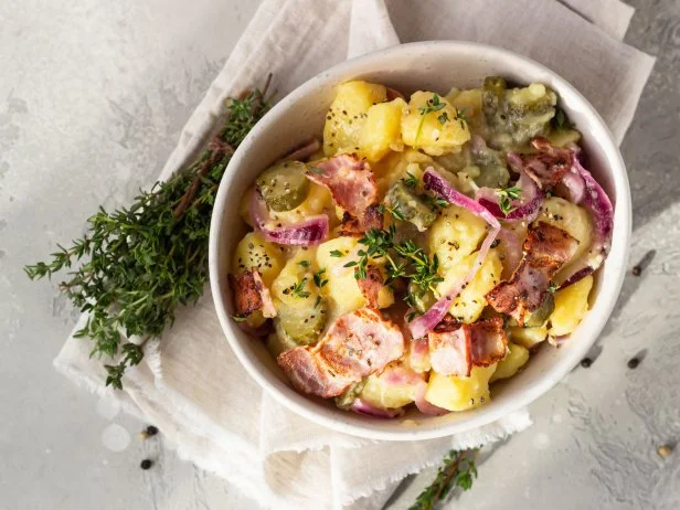 Traditional German potato salad with cucumber, onion and bacon prepared in Swabian-Style (Southern Germany). Kartoffelsalat.