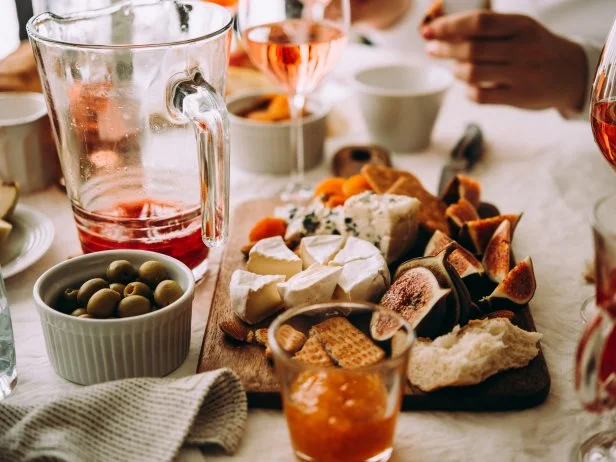 Wooden board with different kinds of cheese and dried fruits. Dinner or aperitivo party concept.