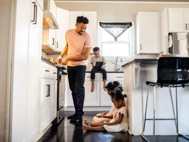 Father cooking breakfast for children