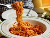 juicy spaghetti with tomato sauce in white plate in restaurant