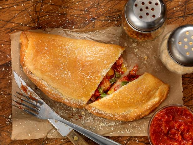 Authentic Hand Made Italian Calzone with Pepperoni, Sausage, Peppers, Fresh Parmesan and Marinara Sauce  - Photographed on a Hasselblad H3D11-39 megapixel Camera System