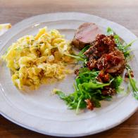 Close-up of Roasted Pork Tenderloin with Bacon Jam and Cheesy Crunchy Noodle Casserole, as seen on The Pioneer Woman, season 30.